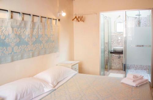 a bedroom with a bed and a glass shower at La Vecchia Torre in Bosa