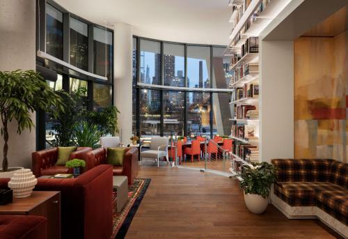 a living room with furniture and a view of a city at Graduate by Hilton New York in New York