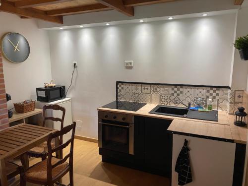 Il comprend une cuisine équipée d'une cuisinière, d'un évier et d'une table. dans l'établissement Chalet cozy au milieu des bois, à Ménestreau-en-Villette