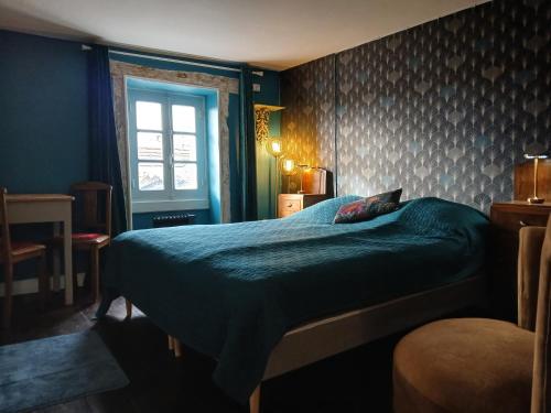 - une chambre avec un lit doté d'une couette verte et d'une fenêtre dans l'établissement Domaine des Pommiers, à Magnac-Laval