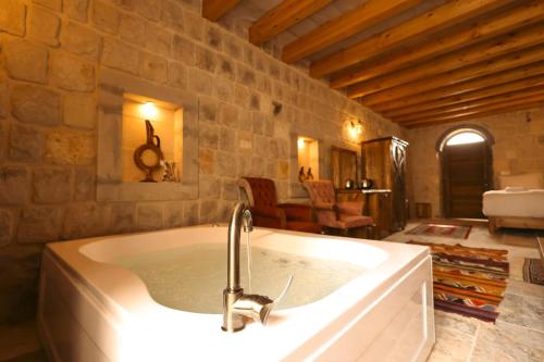 a bath tub with a faucet in a bathroom at Gala Cave Cappadocia in Goreme