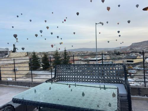 a bench with hot air balloons in the sky at Gala Cave Cappadocia in Goreme