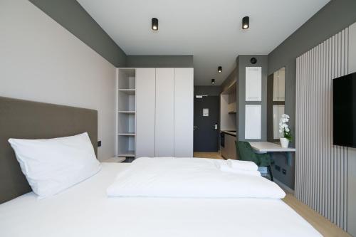 a bedroom with a white bed and a television at Taunus Suites in Oberursel