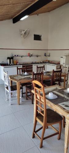 ein Esszimmer mit Holztischen und Stühlen in der Unterkunft Aloha Itaúna in Saquarema