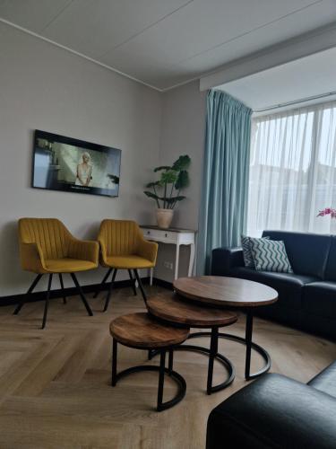 a living room with a couch and a table and chairs at Modern spacious holiday home within walking distance of the North Sea beach in De Koog in De Koog