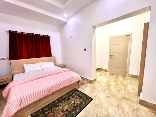 a bedroom with a bed and a red curtain at FURNISHED APARTMENTS UTAKO ABUJA Between Wuse & Jabi District PLS VIEW Flat PHOTOS B4 BOOKING in Abuja