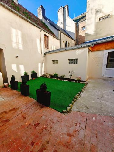 a yard with potted plants in the courtyard of a building at D-Day Suites in Carentan