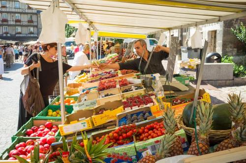 un homme et une femme qui achètent des fruits et des légumes sur un marché dans l'établissement Modern Townhouse in Honfleur with secure parking, à Honfleur