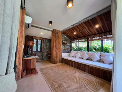 a room with a bench with pillows and windows at LA A NATU Sam Roi Yot in Sam Roi Yot