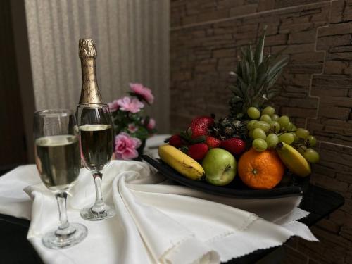 a table with two glasses of wine and a bowl of fruit at Family Hotel Gallery - Sunny Beach in Sunny Beach