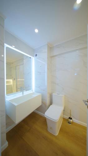 a bathroom with a toilet and a sink and a tub at Front Beach Costa Caparica Lisbon in Costa da Caparica