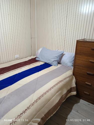 una cama en un dormitorio al lado de una cómoda en Casa en arriendo, en Quintero