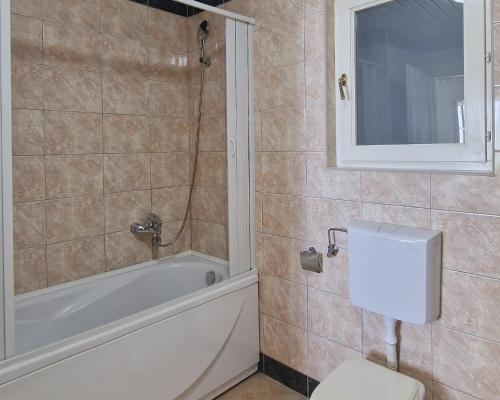 a bathroom with a tub and a toilet and a sink at Luxury Apartments Montesan in Sveti Stefan
