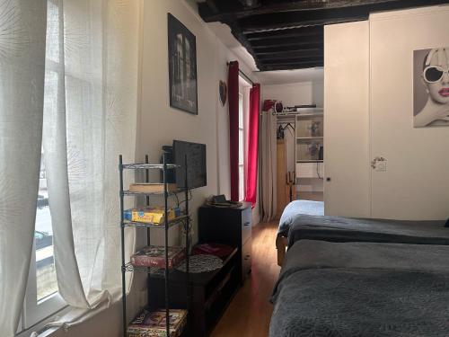 une chambre avec deux lits jumeaux et une fenêtre dans l'établissement Mon Paris, à Paris