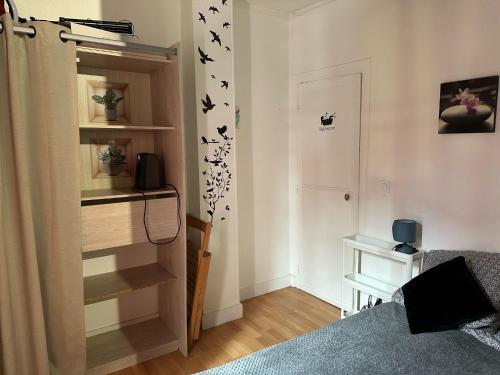 une chambre avec un lit et une étagère avec des oiseaux sur le mur dans l'établissement Mon Paris, à Paris