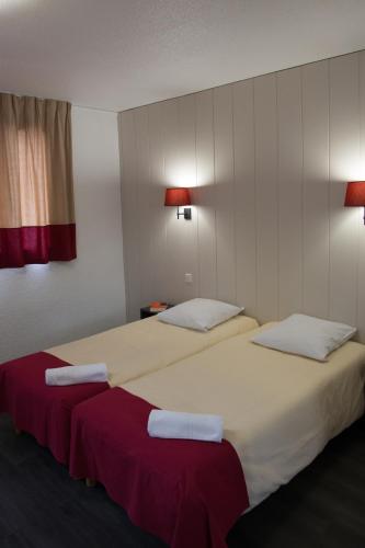 deux lits dans une chambre d'hôtel avec des serviettes dessus dans l'établissement VVF Pays Basque Sare La Rhune, à Sare