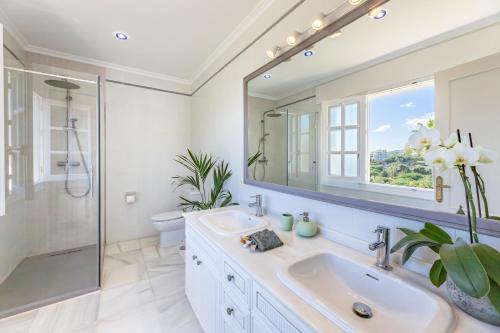 a white bathroom with a sink and a mirror at Aurora Boutique Hotel - Only Adults in Marbella