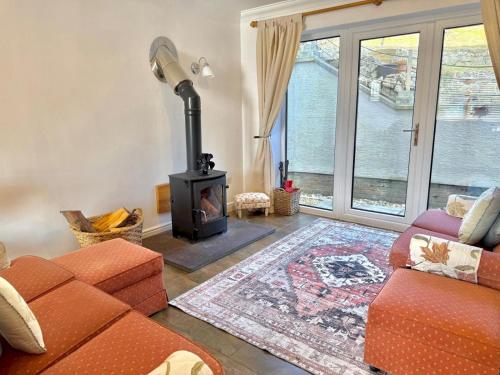 a living room with a couch and a wood stove at Pass the Keys Countryside Retreat in Reynoldston Gower, Sleeps 10 in Reynoldston