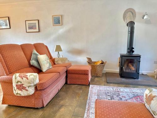 a living room with a couch and a wood stove at Pass the Keys Countryside Retreat in Reynoldston Gower, Sleeps 10 in Reynoldston