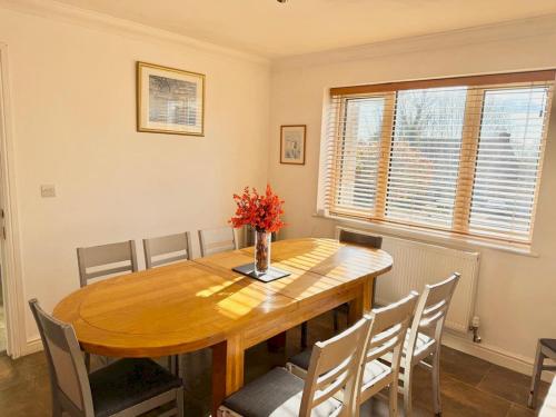 a dining room with a wooden table and chairs at Pass the Keys Countryside Retreat in Reynoldston Gower, Sleeps 10 in Reynoldston