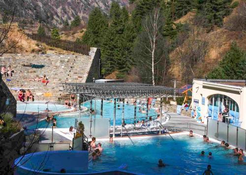 une grande piscine avec des gens dans l'eau dans l'établissement Maison de village wifi clim 3 chambres 2 salles de bain, à Corneilla-de-Conflent