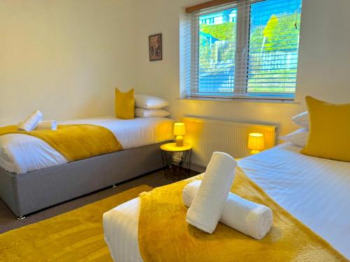 a bedroom with two beds with yellow and white at Pass the Keys Countryside Retreat in Reynoldston Gower, Sleeps 10 in Reynoldston