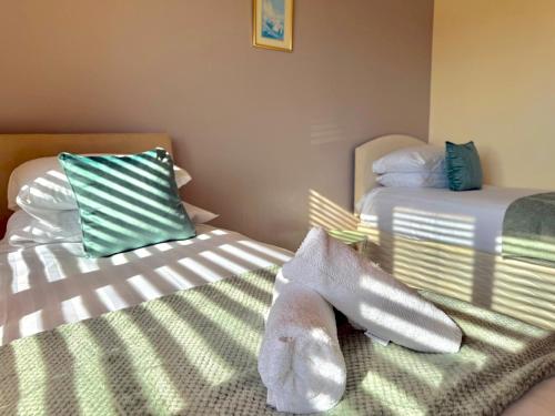 a bedroom with two beds with towels on them at Pass the Keys Countryside Retreat in Reynoldston Gower, Sleeps 10 in Reynoldston