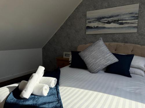 a bedroom with a bed with towels on it at Pass the Keys Countryside Retreat in Reynoldston Gower, Sleeps 10 in Reynoldston