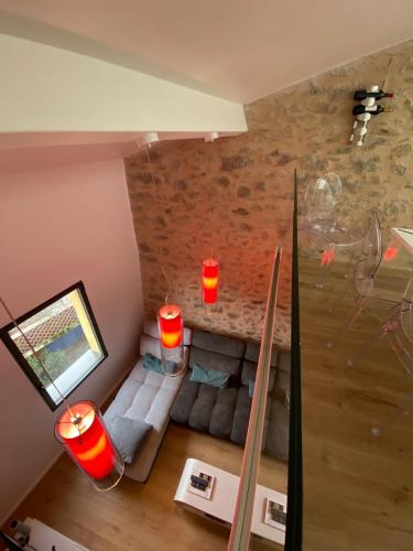un salon avec un canapé et un mur en pierre dans l'établissement Maison de village wifi clim 3 chambres 2 salles de bain, à Corneilla-de-Conflent
