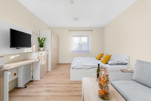 a white living room with a bed and a couch at Nad Šťastným sklepem in Valtice