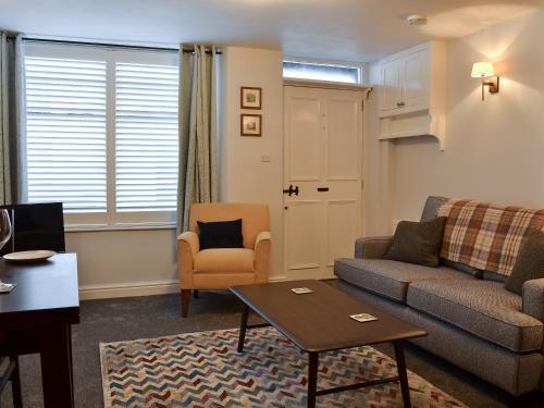a living room with a couch and a table at Lower Sycamore Cottage in Ambleside