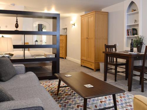 a living room with a couch and a bed and a table at Lower Sycamore Cottage in Ambleside