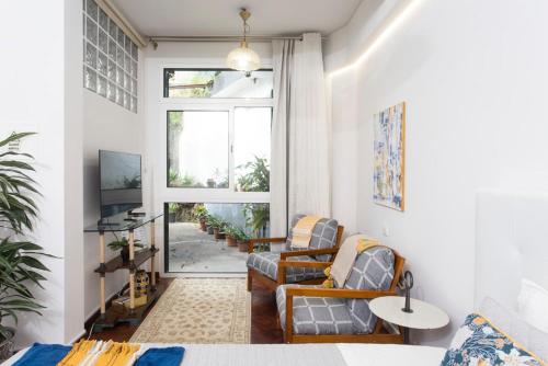 a living room with two chairs and a window at Rochinha Cozy Home in Funchal