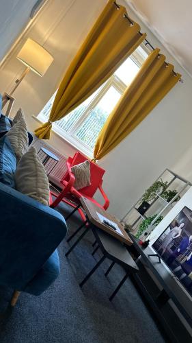a living room with a couch and a table at The Ol-Mumps Cozy Corner in Oldham