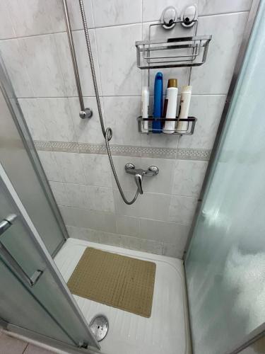 a shower with a glass door and a shelf with toiletries at Duomo Girgenti Loft in Agrigento