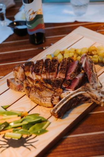 a plate of meat and vegetables on a wooden table at Ca’ Bruno Masaneta in Grado