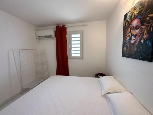 a bedroom with a bed and a painting on the wall at Villa Banana Chill in Sainte-Luce