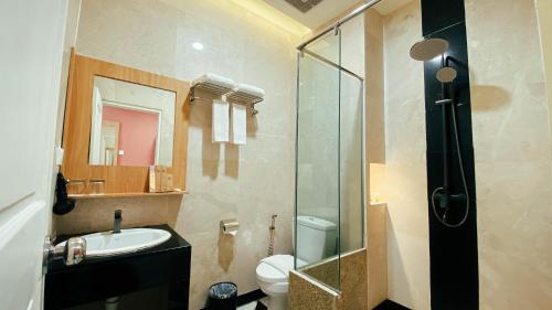 a bathroom with a toilet and a sink and a shower at Agro Hotel Bintan in Telukbakau