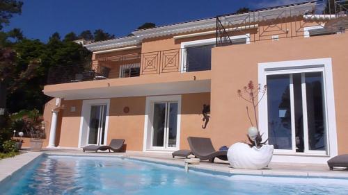 une maison avec une piscine devant une maison dans l'établissement l olivier de Melody, à Saint-Raphaël