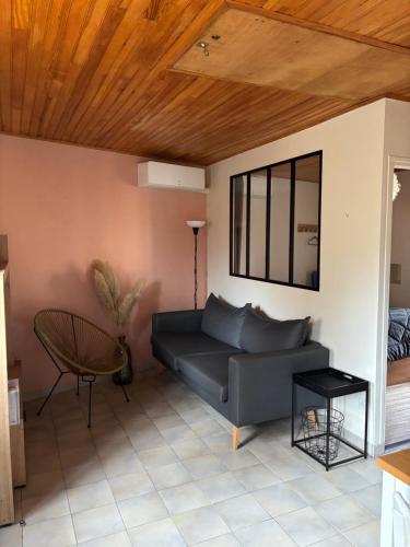 - un salon avec un canapé et un plafond en bois dans l'établissement Le gîte de Lili, à Payrignac