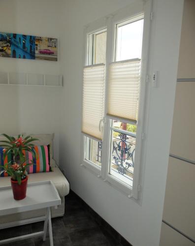 a room with two windows and a couch and a table at La Cadanise, Suite Étoilée in Saint-Éloy-les-Mines