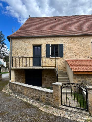 Cette maison en briques dispose d'un balcon et d'un escalier. dans l'établissement Le gîte de Lili, à Payrignac