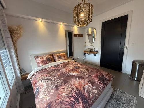 a bedroom with a bed with a flowery comforter at Hart van Petten in Petten