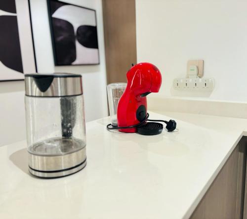a red object is sitting on a kitchen counter at Luxury 1BR Apt Best view Infinity Pool Burj Khalifa with Balcony in Dubai