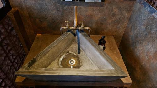 a stone sink in a room with a candle at The Backyard Balangoda in Balangoda