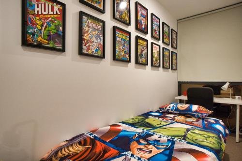 a room with a bed and some pictures on the wall at DC vs Marvel Theme ft Arcade Machine Pool Gym Sauna BBQ in Adelaide
