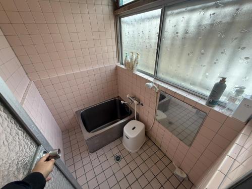 a person taking a picture of a bathroom with a toilet at SUWAHouse in Gora