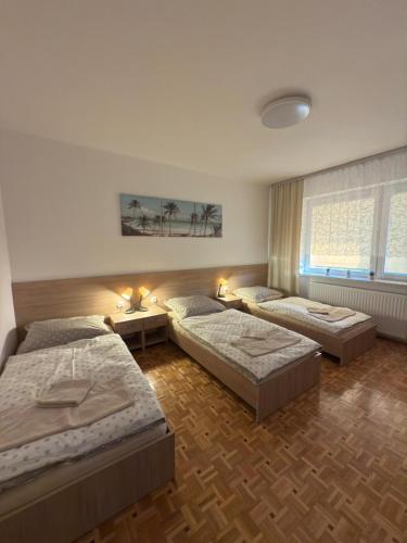 a bedroom with three beds and a window at Apartament Jaśminowa in Chrzanów