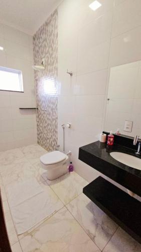 a bathroom with a toilet and a sink and a mirror at Casa Bela Vista in Capitólio
