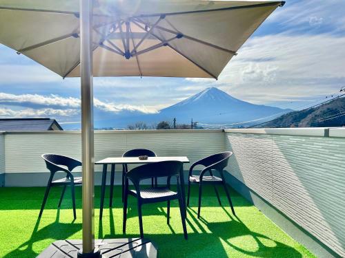 a table and chairs under an umbrella on a balcony at NewOpen大石100B広い展望台, 富士山と河口湖を望む 近大石公園 in Fujikawaguchiko